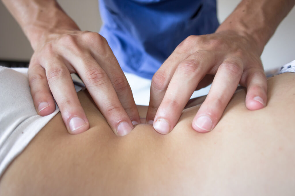 osteopath hands on patient back massage